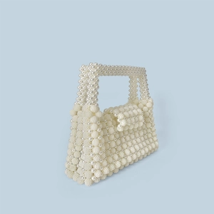 Detail of handmade pearl beaded handbag showing intricate weave and elegant flap closure