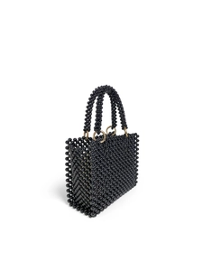 Detail view of handmade black beaded handbag with golden metal hardware and pearl texture