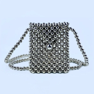 Detailed close-up of handmade silver beaded crossbody bag with metallic chain strap