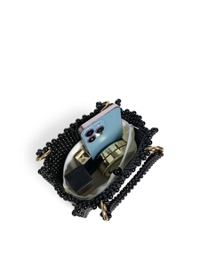 Top view of handmade black beaded bag showing storage capacity with phone and cosmetics