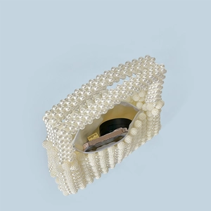 Detailed interior of handmade pearl beaded bag showing zipper lining and small cosmetics