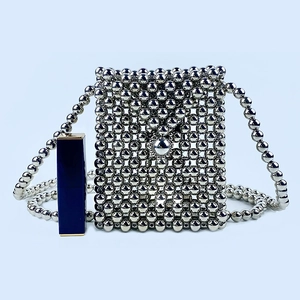 Detailed view of silver handmade beaded mini bag with metallic texture and round strap