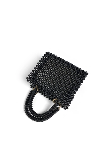 Detail of handmade black beaded handbag featuring polished beads and gold metal rings