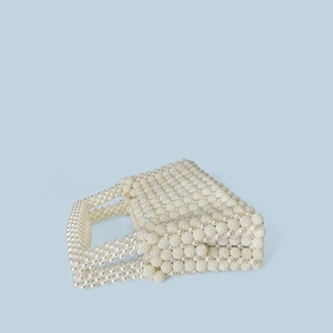 Close-up of handmade woven pearl handbag showing intricate beadwork and texture