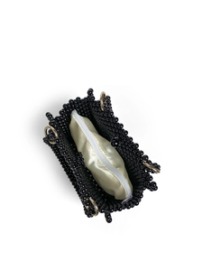Detailed view of handmade beaded handbag with a yellow satin zipper pouch and gold hardware