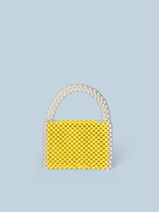Handmade yellow beaded box bag with white pearl handle on a light blue background