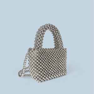 Detailed view of silver metallic bead weaving on a handcrafted mini crossbody handbag