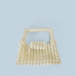 Close-up of handmade white pearl woven handbag showing detailed round bead craftsmanship