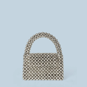 Détail macro du motif de perles acryliques tissées sur le sac argenté