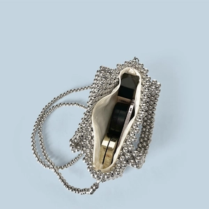 Detail of silver beaded handbag showing inner fabric lining and zipper closure space