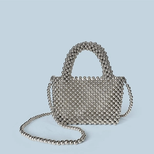 Detail of silver beaded handbag showing intricate metallic weave and rounded top handle