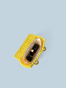 Sac à main fait main en perles jaune vif avec fermeture éclair blanche sur fond bleu