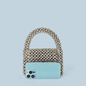 Vue détaillée d'un sac enveloppe tissé avec des perles acryliques à facettes argentées