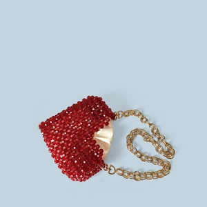 Détail des perles rouges avec doublure en satin champagne et chaîne dorée chic