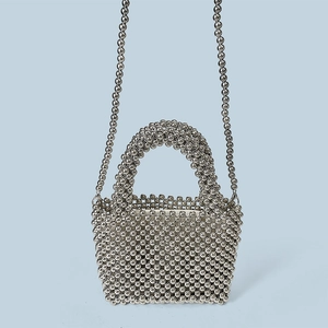Macro view of silver metallic bead weaving on the mini handbag with shoulder strap
