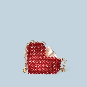 Détail du sac à perles rouge en forme de cœur avec bandoulière chaîne dorée