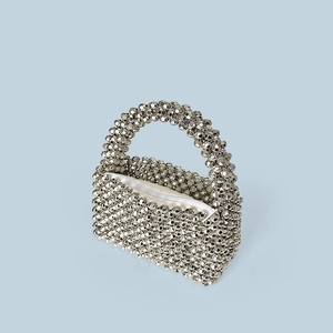 Détail macro du sac bandoulière en perles acryliques argentées avec texture tissée et zip