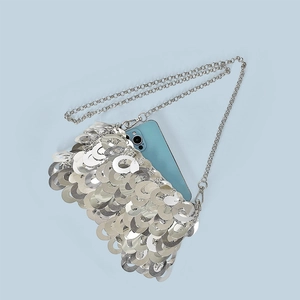 Detailed view of silver sequin chain bag showing interior space for a smartphone