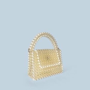 Detail of handmade beaded handbag with cream pearls and transparent woven grid pattern