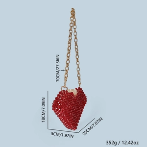 Détail du sac perlé rouge en forme de cœur 3D avec une bandoulière en chaîne dorée