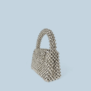 Détail du sac enveloppe argenté montrant la texture des perles acryliques tissées main