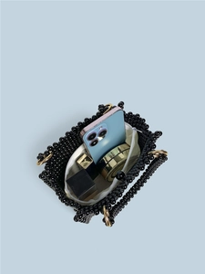 Handmade black beaded handbag with top zipper showing inner storage for phone and lipstick
