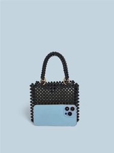 Handmade black beaded handbag with gold rings shown next to a phone for size reference