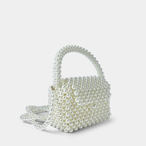 Detail der handgefertigten weißen Perlenhandtasche mit Klappverschluss und edler Kette