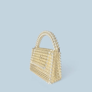Detail of handmade beaded handbag with ivory pearls and transparent acrylic beads