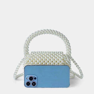 Mini-Perlenhandtasche im Größenvergleich zu einem Smartphone im Detail