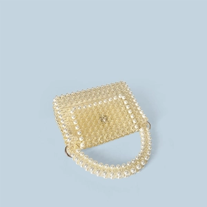Close-up of handmade beaded handbag with yellow prism beads, pearl trim and floral metal clasp