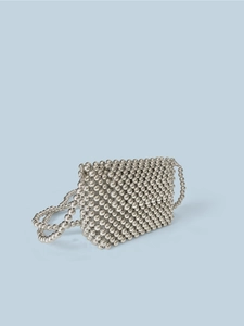 Handcrafted silver beaded mini crossbody bag with a metallic finish on a blue background