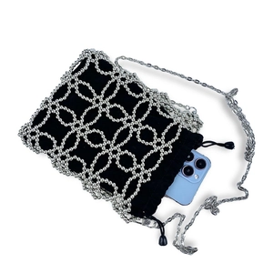 Detail of beaded mesh crossbody bag with drawstring closure showing phone capacity