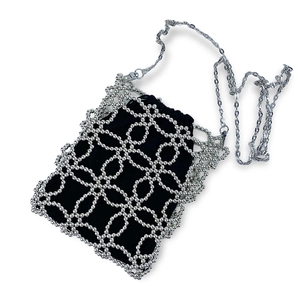 Detailed view of silver beaded mini square bag with black drawstring inner pouch