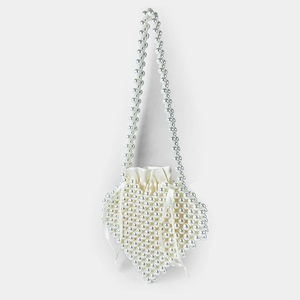Detailed view of handmade pearl heart-shaped mini bag with white satin drawstring closure
