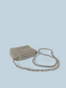 Close-up of handmade woven silver metal beads and long chain strap on crossbody bag