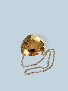 Macro shot of gold sequin crossbody bag with metallic heart frame and luxury chain strap