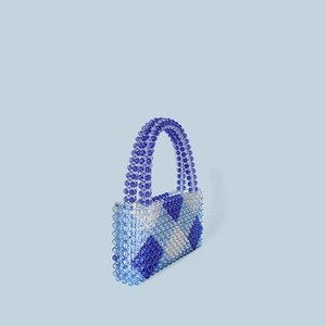 Detail einer gewebten Perlenhandtasche mit blau-weißem geometrischem Rautenmuster