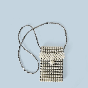 Dettaglio della mini borsa a tracolla fatta a mano con perle e dischi metallici