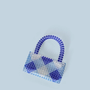 Detail der handgefertigten blau-weißen Perlenhandtasche mit geometrischem Dreiecksmuster