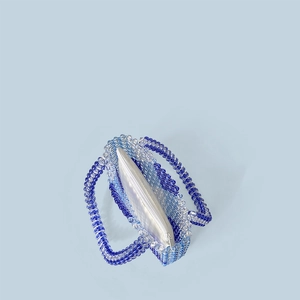 Detailansicht der gewebten Perlen-Handtasche mit blauem Verlauf und Satin-Innentasche