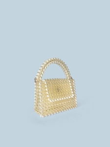 Handmade beaded mini handbag with champagne crystals and white pearl accents on blue backdrop