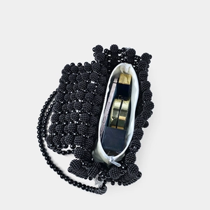 Draufsicht einer schwarzen Perlenhandtasche mit Platz für Handy und Make-up