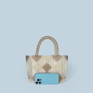 Detail of beaded tote bag with diamond pattern and a phone for size comparison