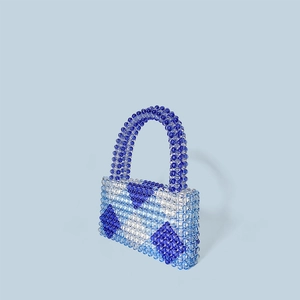 Detailaufnahme des Rautenmusters und der Perlenstruktur an einer Mini-Handtasche