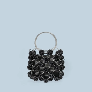 Detail of black beaded handbag with silver metal rings and satin lining texture
