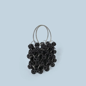 Detail of hand-beaded handbag with silver metal rings and black beads with satin pouch