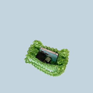 Handmade green beaded handbag showing interior storage for phone and lipsticks