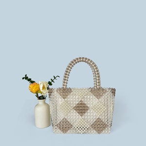 Macro detail of handmade beaded tote with diamond pattern and pearl grey acrylic beads