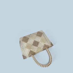 Macro shot of handmade beaded handbag showing brown and clear diamond weave pattern
